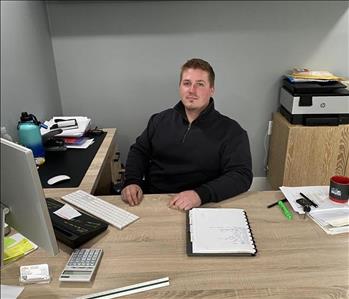Joseph, sitting at his desk, is always ready for water and fire disasters!